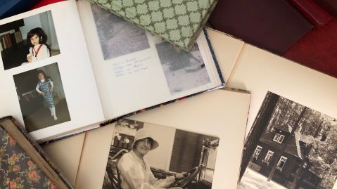 Mehrere Bücher und Fotoalben auf einem Tisch.