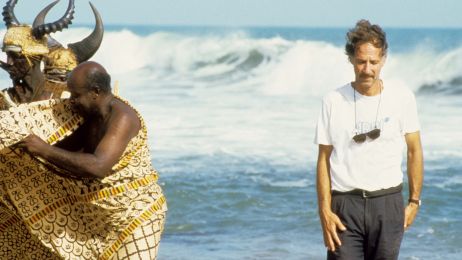 Director Werner Herzog on the beach, on the right, together with actors standing on the left.