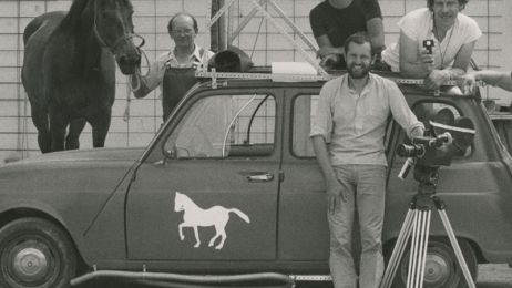 Four men, a car and a horse pose for a photo during filming.